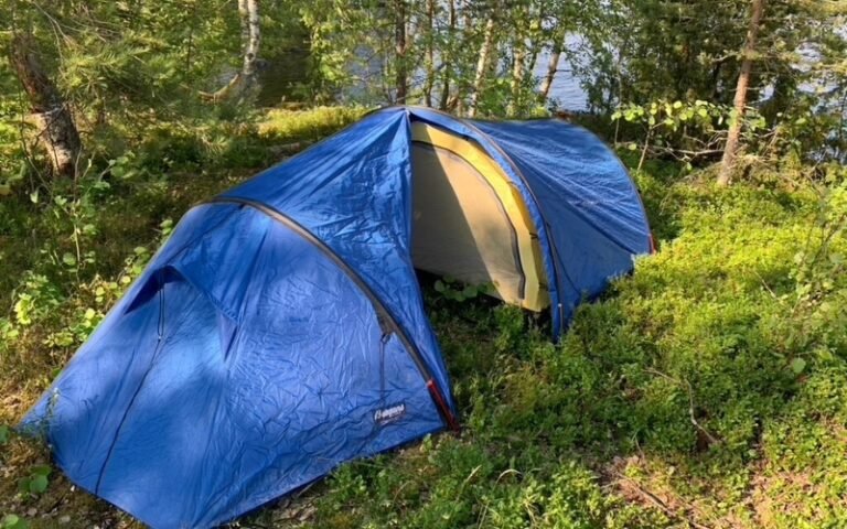 Vaellusteltta metsässä järven rannalla
