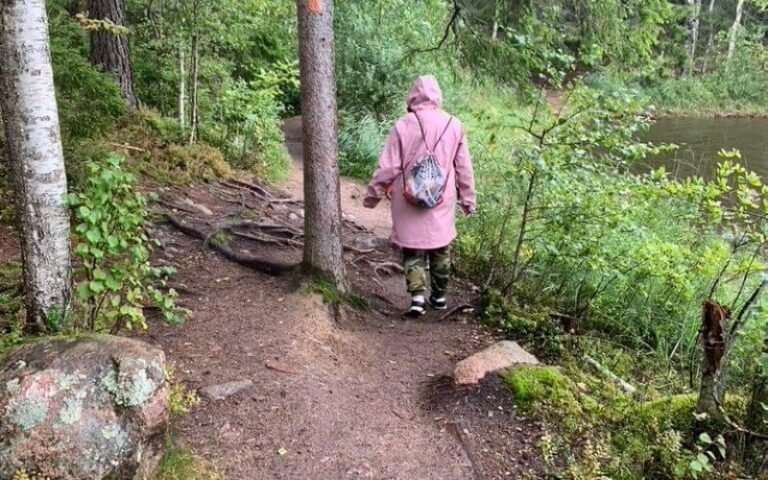 Retkeilijä kulkee metsäpolulla järven rannalla